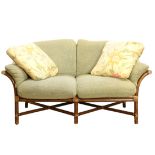 McGuire, San Francisco, love seat, having sage upholstered cushions, above a faux bamboo frame, 33.