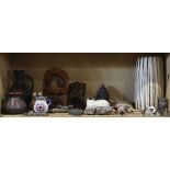 Two shelves of decorative art including Native American style pottery and masks, together with