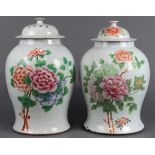 (lot of 2) Chinese enameled porcelain lidded jars, each of lush peonies of various hues, reversed by