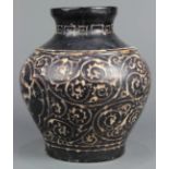 Chinese Jizhou type ceramic jar, featuring reserves of pines amid scrolling tendrils on a dark brown