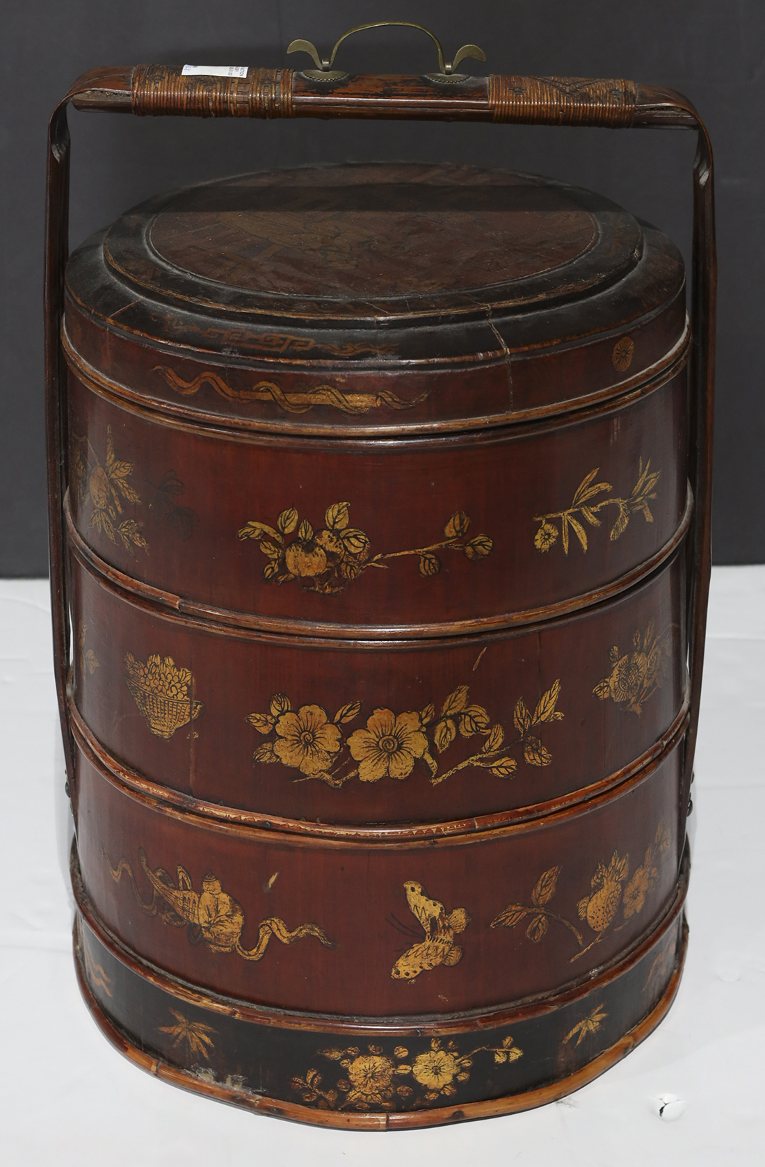 Chinese three tiered food basket, the circular lid featuring three figures in gilt, 23.75"h