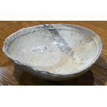 Brutalist style studio ceramics serving bowl, having a mottled cream color glaze, impressed "P."