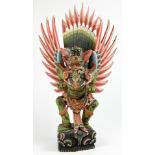 Indonesian polychrome wood Garuda, with detachable wings connected to the green body, standing on