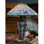 Tiffany style leaded glass table lamp, having a jeweled peacock feather form shade above the