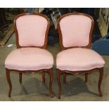 Pair of French walnut fauteuils, each having a shaped back with floral carved crest and rising on