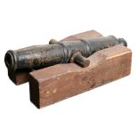 Cast iron table cannon, having a closed barrel resting on a wood base, 7"h x 8"w x 18"d