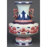 Chinese underglaze blue and red porcelain vase, the trumpet neck flanked by lion form handles,