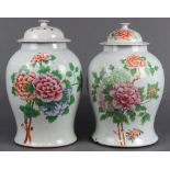 (lot of 2) Chinese enameled porcelain lidded jars, each of lush peonies of various hues, reversed by