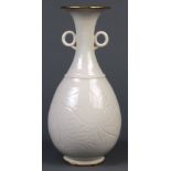 Chinese white glazed bottle vase, with a trumpet neck flanked by ring handles, the pear shaped
