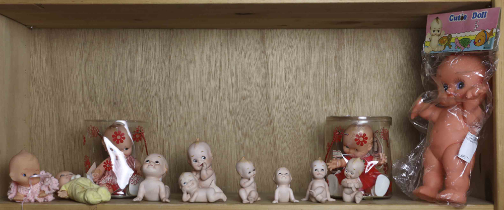 One shelf of Kewpie Dolls, comprising seven bisque dolls in various poses, three Cameo character