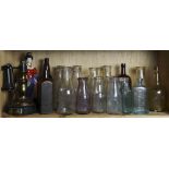 One shelf of mostly vintage clear and colored bottles, including a labeled Hostetters Stomach
