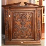 Carved wood cabinet, having a bonnet top above the single door case, carved in low relief with