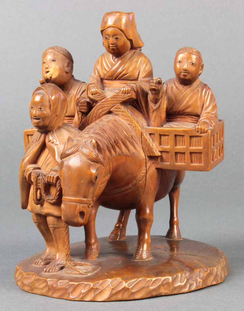 Japanese wood sculpture of tsuge wood, a woman and two boys riding on a horse, led by a smiling man,