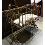 Victorian brass baby crib circa 1860, having period silk textiles and rising on a footed base, 70"