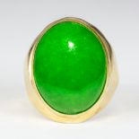 Jadeite and 18k yellow gold ring Featuring (1) oval jadeite cabochon, measuring approximately 23.4 X