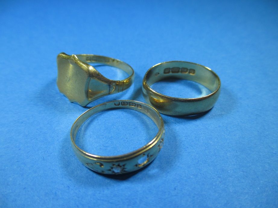 A 22ct gold wedding band and two 18ct gold rings, approx. weight 10.9g