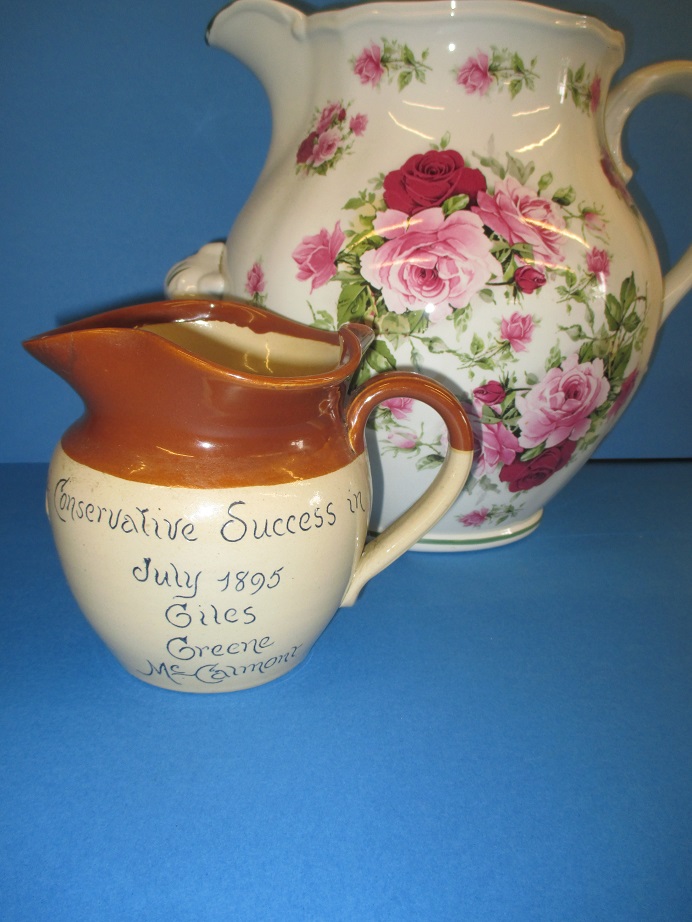 An 1895 stoneware commemorative jug and a large floral decorated jug