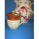 An 1895 stoneware commemorative jug and a large floral decorated jug