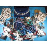 A quantity of vintage costume jewellery to include shell necklaces