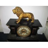 A late 19th century cast iron mantle clock with lion finial