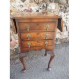 A walnut 3 drawer bedside cabinet with 2 lift up flaps