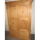 A pine double wardrobe with a 4 drawer base