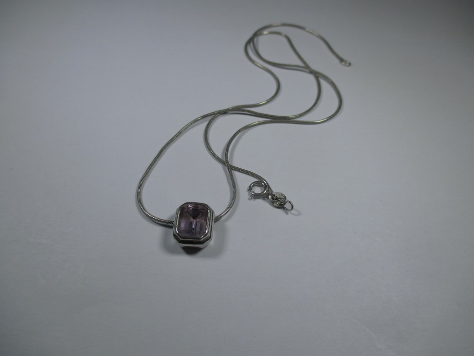 A 9ct white gold necklace with amethyst set pendant