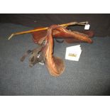 A saddle, riding crop and hunting book