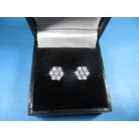 A pair of 9ct white gold and diamond daisy earrings