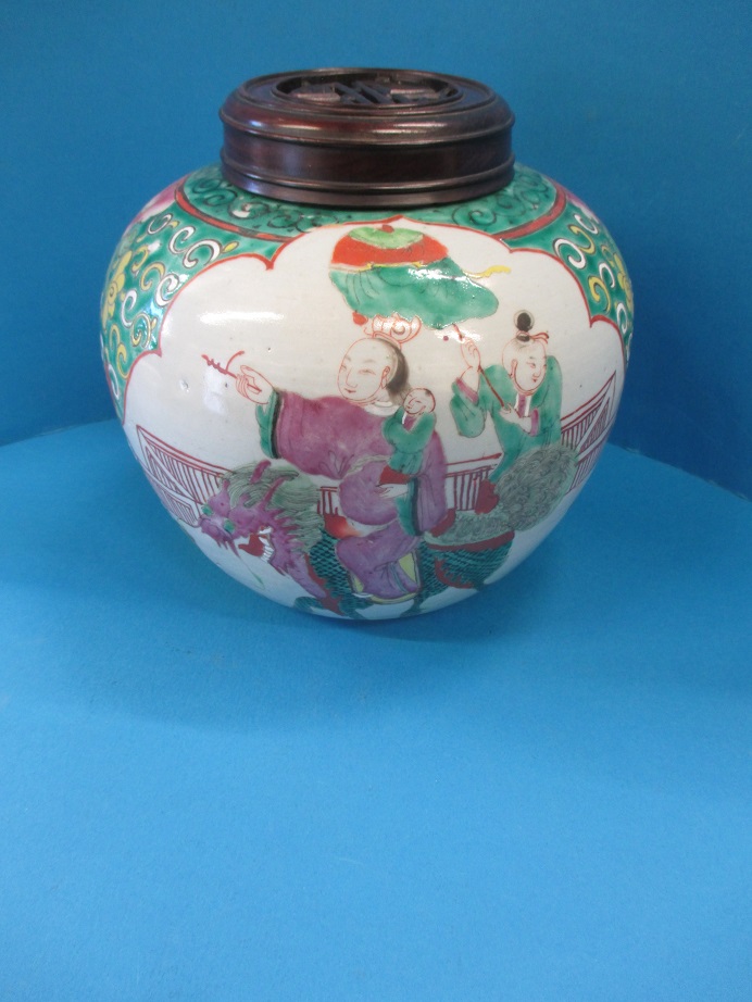 A 19th century Chinese porcelain jar and carved wood cover with polychrome decor