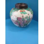 A 19th century Chinese porcelain jar and carved wood cover with polychrome decor