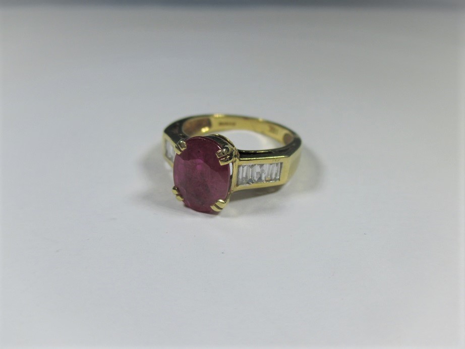 An 18ct yellow gold ruby ring with baguette diamonds to shoulders, approx ring s