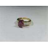 An 18ct yellow gold ruby ring with baguette diamonds to shoulders, approx ring s