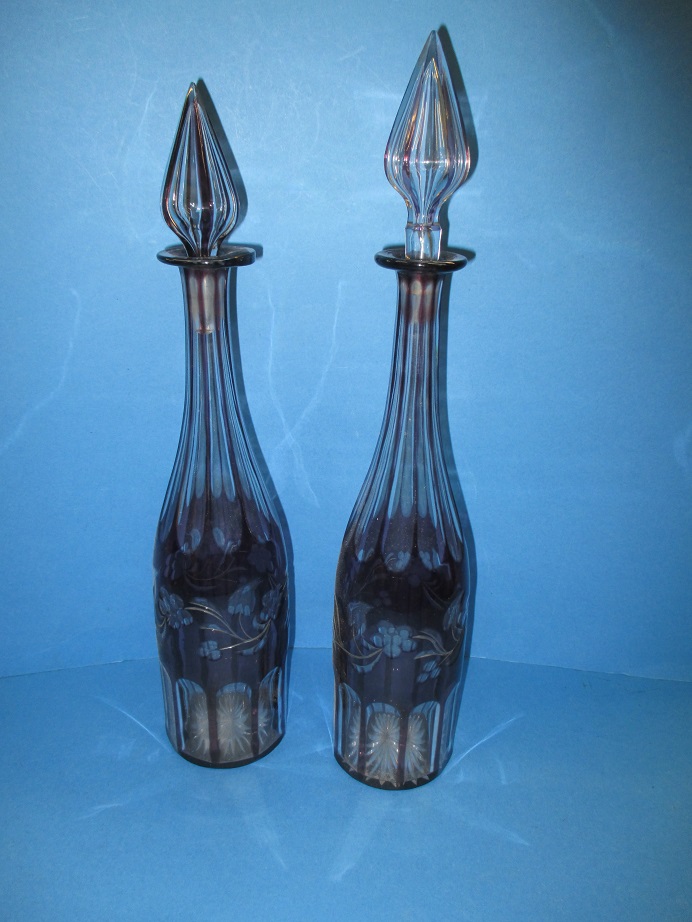 A pair of bohemian amethyst glass decanters. Register and bid at https://clareau