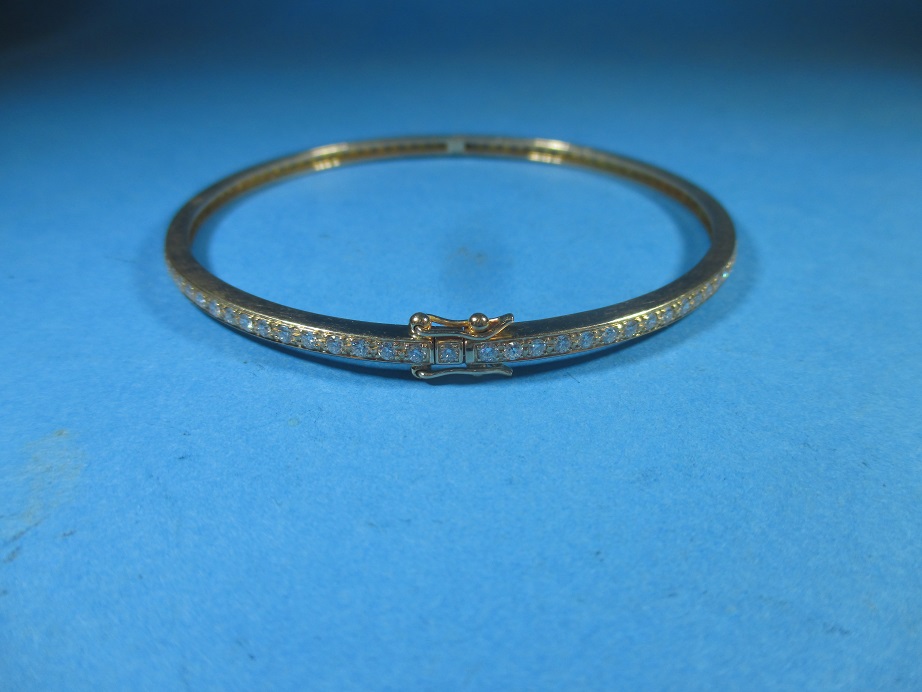 An 18ct gold diamond set bangle, approx weight 14g