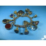 A gold charm bracelet with numerous hardstone fob seals, approx total weight 89.