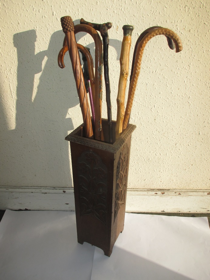 A vintage stick stand and a quantity of sticks