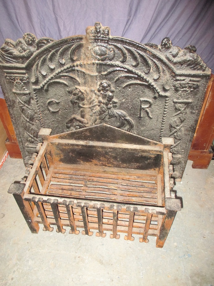 A large cast iron fire back and a fire basket