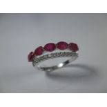 An 18ct white gold ruby and diamond half eternity ring, approx finger size P
