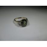 A 9ct yellow gold ring with central Peridot and 4 diamonds to each shoulder, approx. ring size P