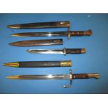 Three vintage bayonets in scabbards