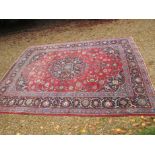 A large vintage hand woven wool rug 8ft 6" x 10ft 6"
