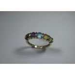 A 9ct gold ring set with various coloured sapphires