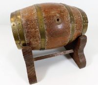 A coopered oak barrel with brass fittings & stand