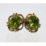 A pair of yellow metal earrings with peridot stone