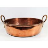 A large copper pan with brass handles 17in wide