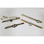 Four yellow metal bar brooches with various stones