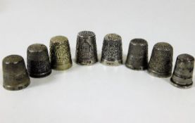 A collection of eight silver & white metal thimble