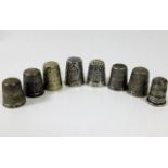 A collection of eight silver & white metal thimble