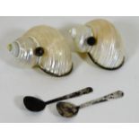 A pair of caviar serving shells with spoons